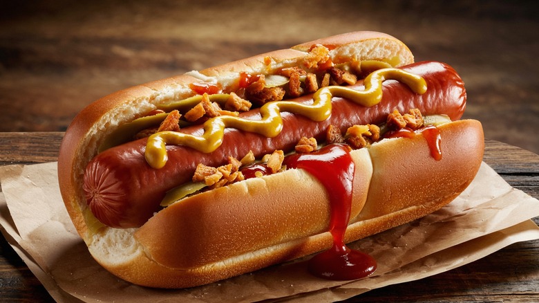 Close up of crispy hot dog with ketchup and mustard on napkin