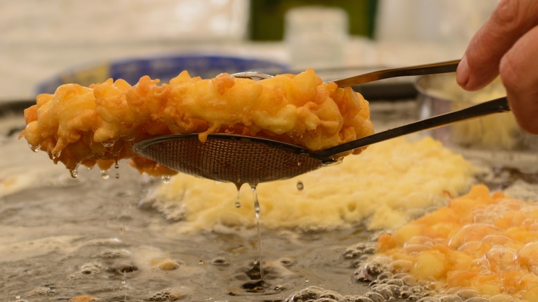 Man lifting breading out of deep fryer