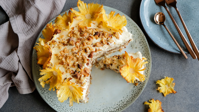 A pineapple flower and pecan hummingbird cake has a slice removed