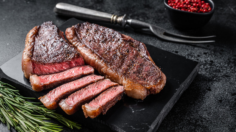 Cuts of grilled sirloin on slab of stone.
