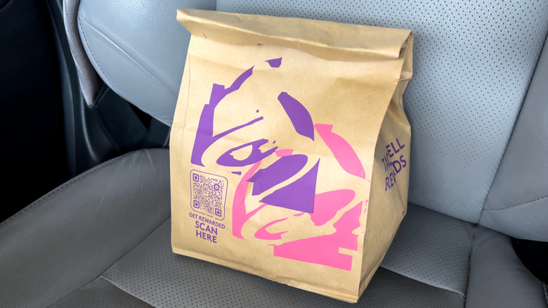A Taco Bell to-go bag sits in a passenger side car seat