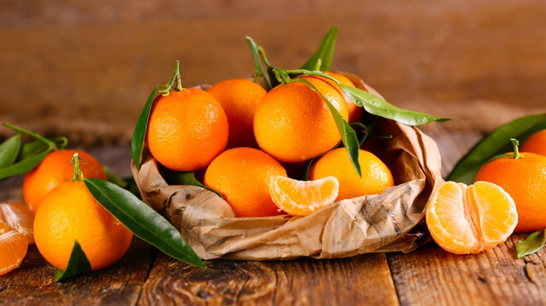 Brown paper bag of orange clementines