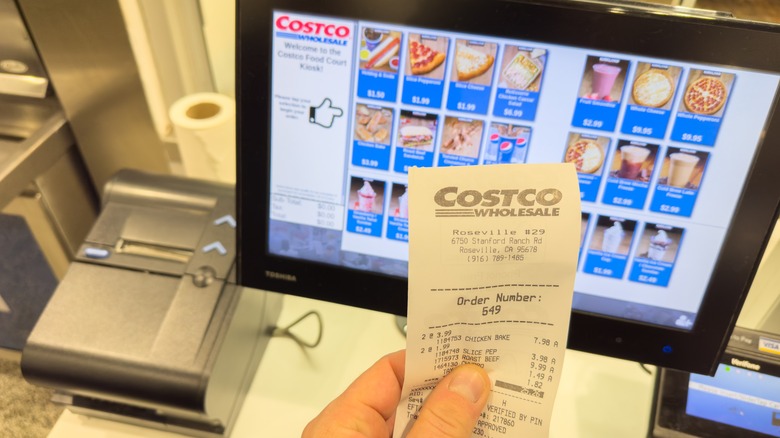 Customer holding Costco receipt at self-check out in the food court
