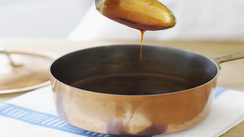A spoon with caramel on it.