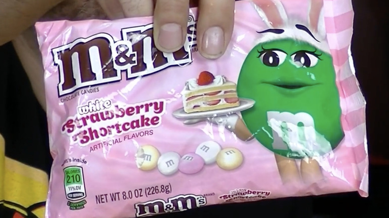 Hands holding a bag of discontinued White Strawberry Shortcake M&M's