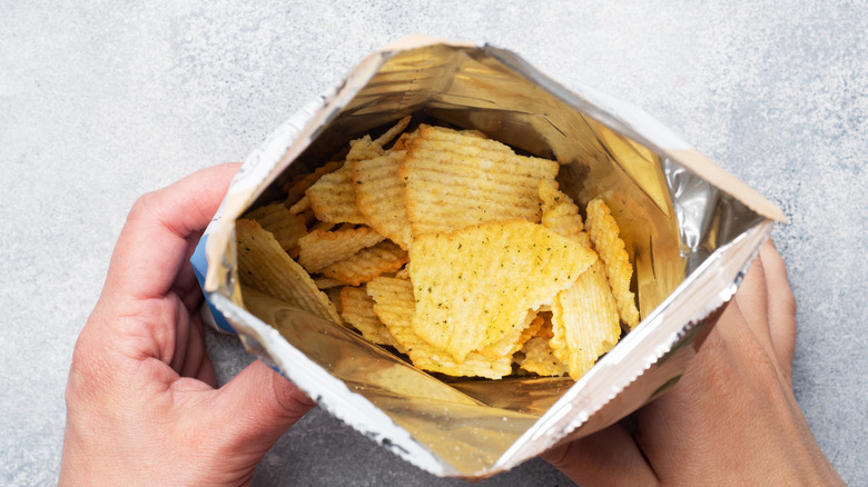 Opened bag of potato chips pictured.