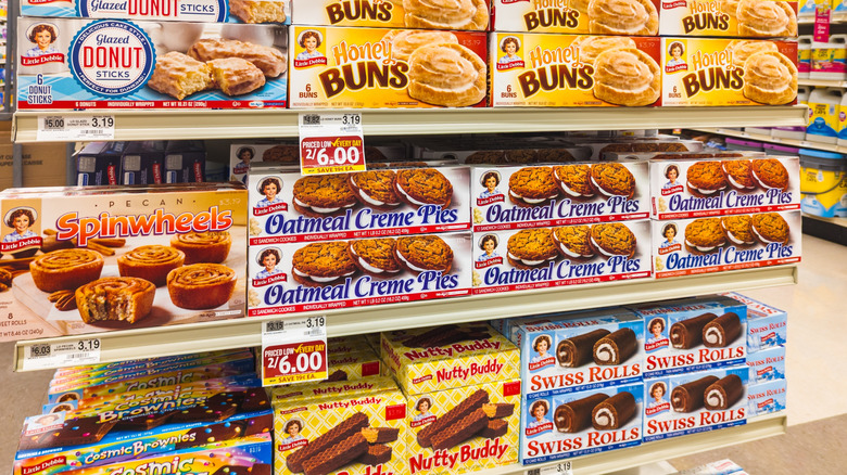 A grocery store aisle with boxes of various Little Debbie treats