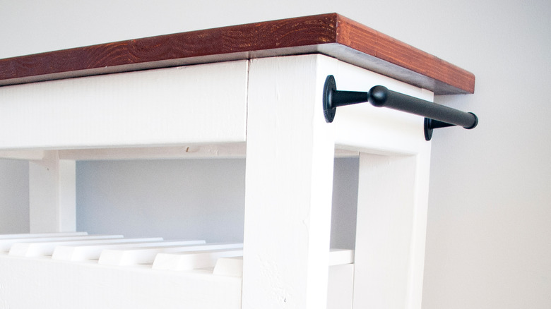 Kitchen island table with towel rack attached to side