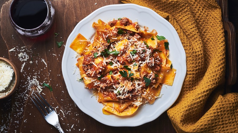 pasta in meaty sauce with herbs and grated parmesan as garnish