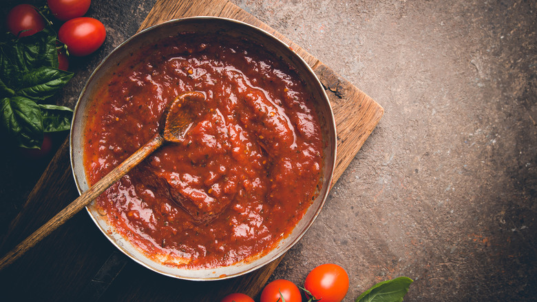 pan of pasta sauce with dried herbs and aromatics