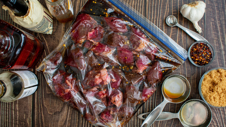 marinating steak tips in a plastic bag with the ingredients used on the table
