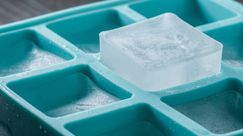 Blue silicon ice mold with raised ice cube sticking out