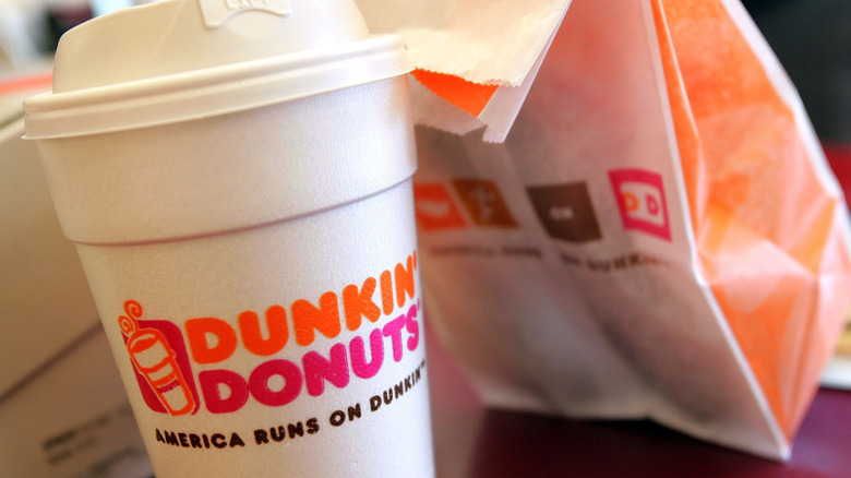 Dunkin' coffee cup and a to go bag