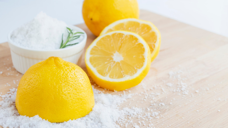Halved lemons and a bowl of salt
