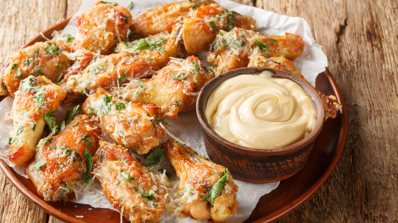 Garlic parmesan wings on a plate with a dipping sauce