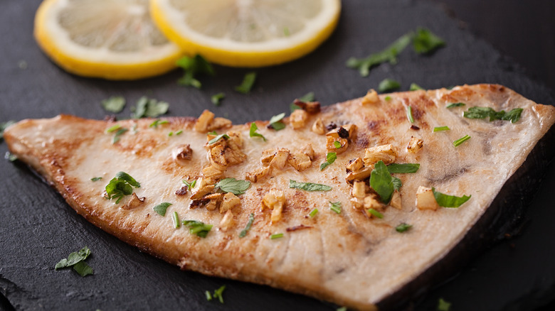 Cooked fish with cilantro and fried garlic topping