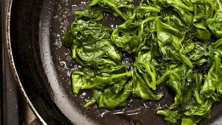 Baby spinach sauteing in a pan