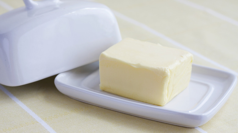 A stick of butter in a beautiful ceramic dish