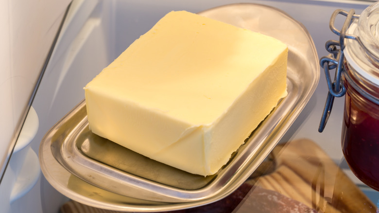 A stick of butter on a dish in the fridge
