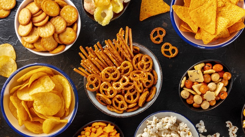 different snacks - pretzels, chips, crackers, in bowls