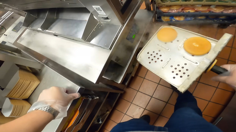A McDonald's worker removes steamed buns from a Filet-O-Fish steamer