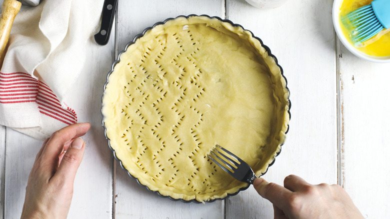 Empty raw pie crust on flour-covered table