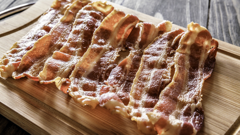 crispy bacon on wooden cutting board