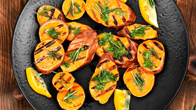 Grilled sweet potatoes on a black plate