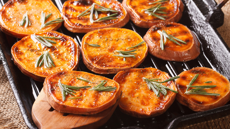 Sliced grilled sweet potato with sprigs of rosemary