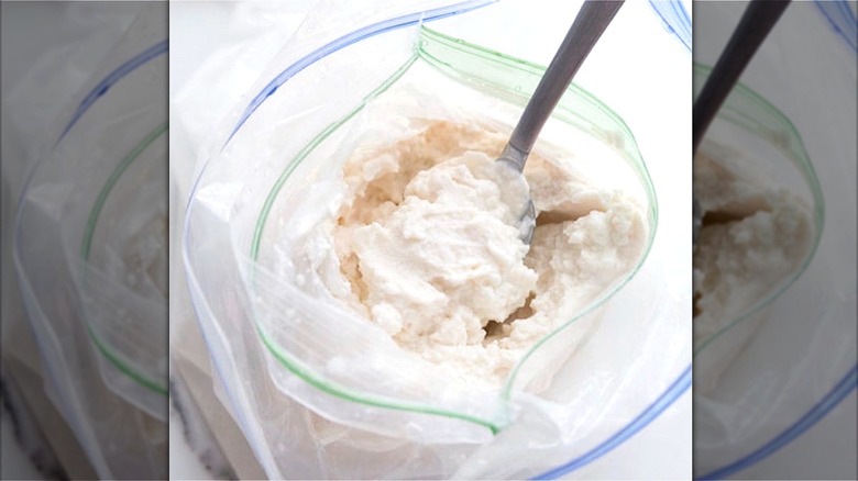 Vanilla ice cream made in a plastic bag with a metal spoon
