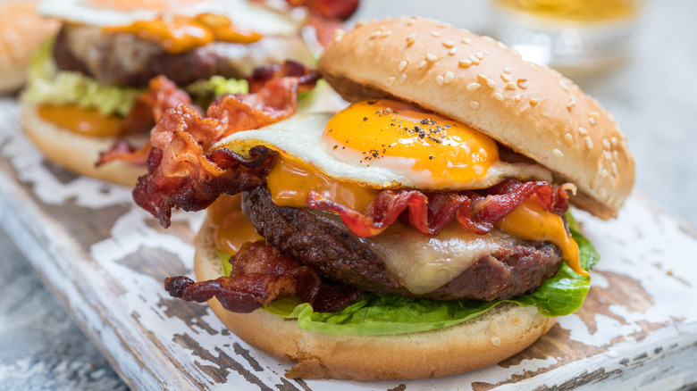 a perfectly fried egg on a cheeseburger with bacon