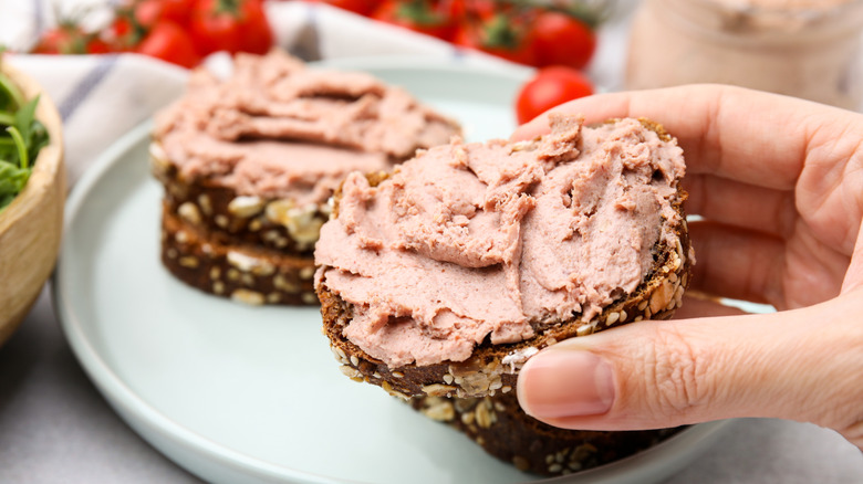 person holding liverwurst sandwich
