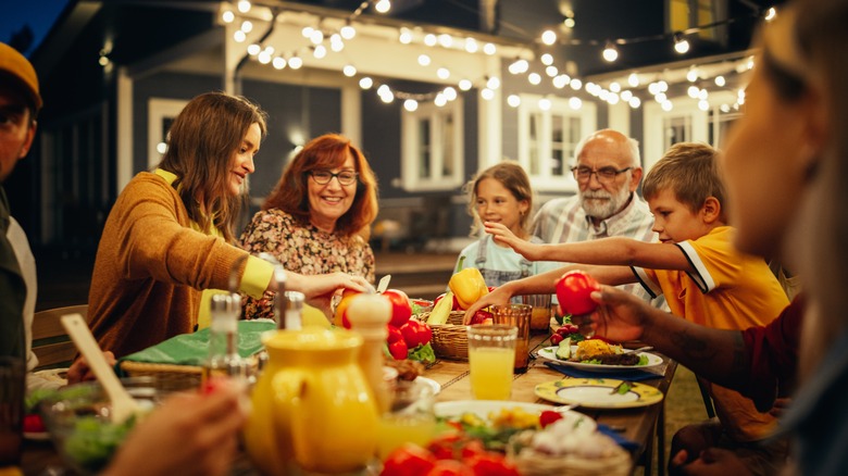 outdoor dinner party with people gathered around table