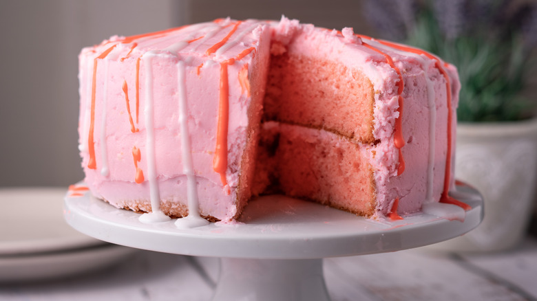 Pink cake with pink frosting on stand