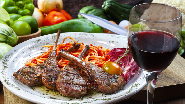 plate of lamb chops next to glass of wine