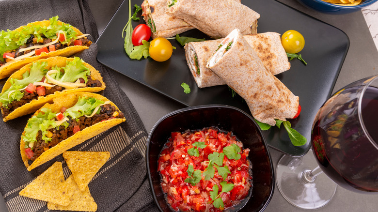 Tacos and burritos with red wine glass