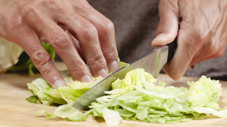 A man chops up cabbage using a sharp knife