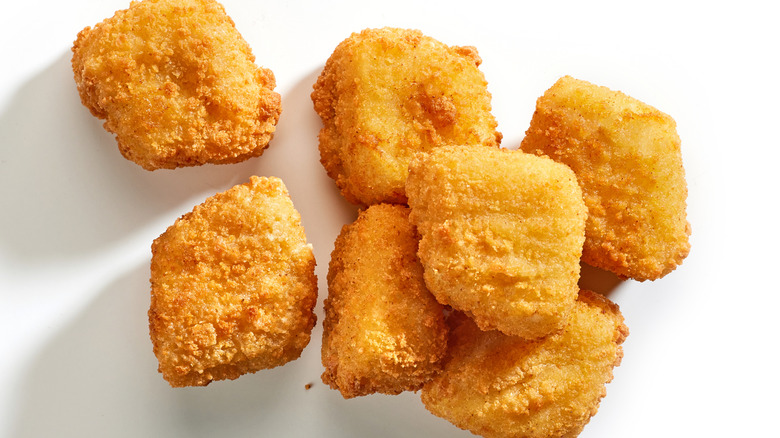 Fish nuggets sit on a white background.