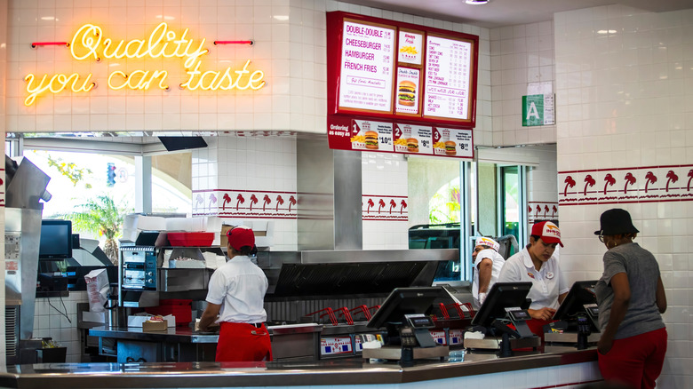 A customer orders at a counter inside an In-N-Out restaurant
