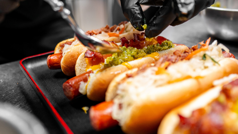 four hot dogs topped with various toppings