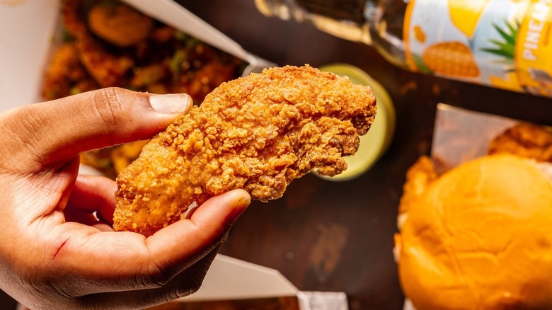 Hand holding a piece of Sticky's chicken