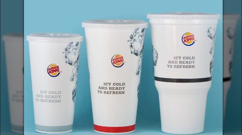 Three different sizes of Burger King sodas lined up against a blue background