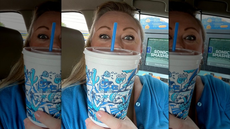 Customer holding a Route 44 in a car in a Sonic Drive-In