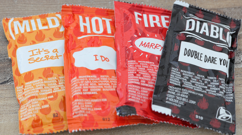 Four Taco Bell sauce packets in the flavors Mild, Hot, Fire, and Diablo