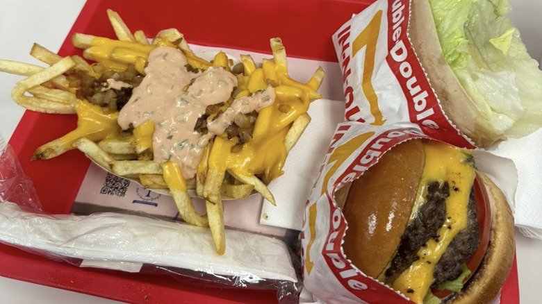 Animal-style fries from In-N-Out sit on a tray with a burger