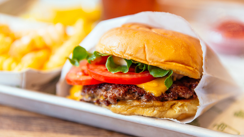 A burger and fries from a fast-food establishment sit on a tray