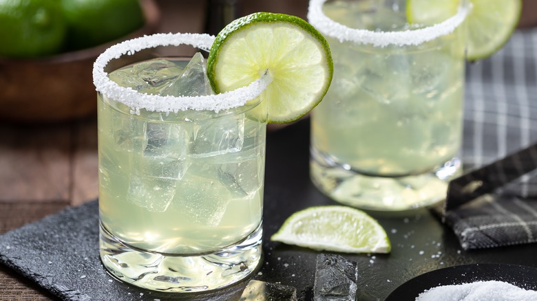 two classic margaritas with lime wheels