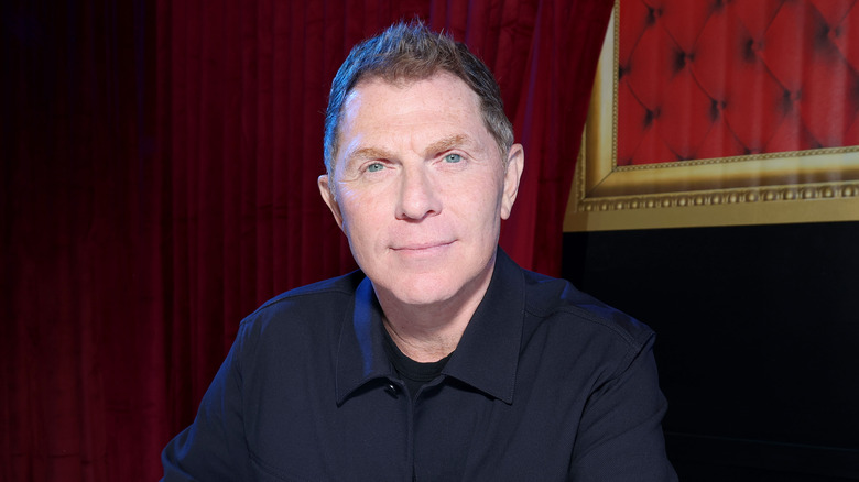 Bobby Flay in front of deep red curtain
