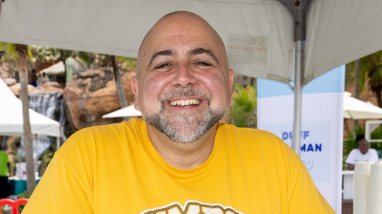 Duff Goldman in yellow t-shirt under outdoor tent