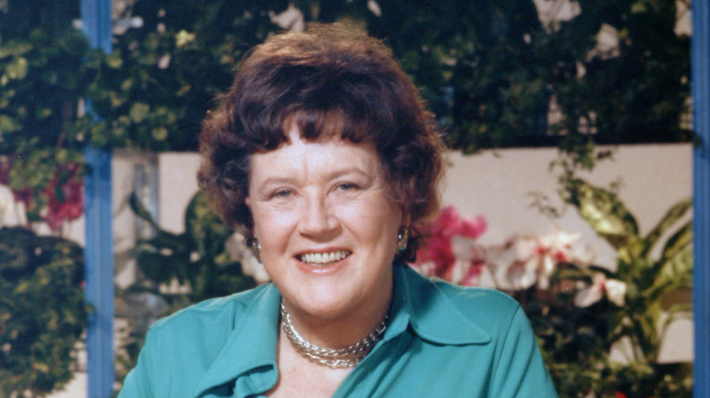 Julia Child posed in front of outdoor garden
